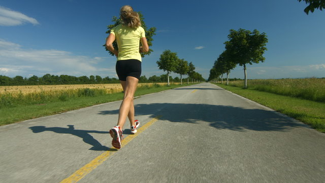 woman jogging on road in spring