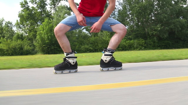 Young handsome man rollerblading in park on a beautiful day, doing some tricks