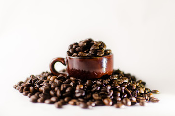Roasted brown coffee beans & mug  isolated in white background