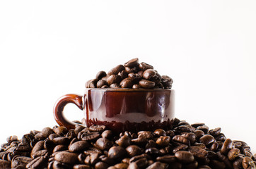 Roasted brown coffee beans & mug  isolated in white background