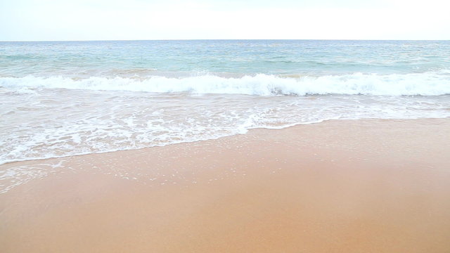 Waves washing over white sand in the tropics