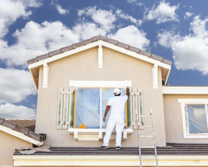 House Painter Painting the Trim And Shutters of Home