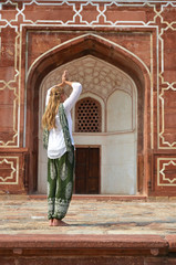 Fototapeta na wymiar Young woman meditating in the yard of Humayun's Tomb. Delhi, Ind