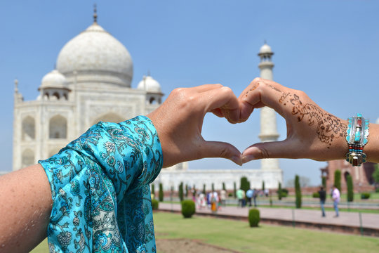 Heart-shaped hands against Taj Mahal. Agra, India