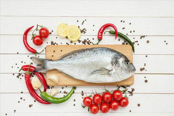 Fresh dorado fish with lemon on wooden cutting board