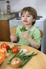 Adorable Little Boy Making Funny Face While Eating Parsley