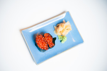 Gunkan, sushi on blue plate with ginger and wasabi