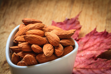 Almonds in bowl on autumnal background