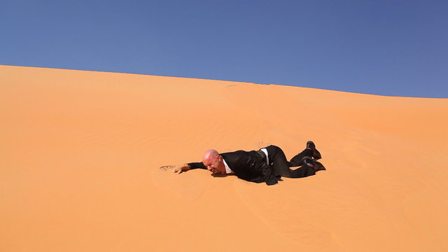 desperate businessman in desert dunes thirsty