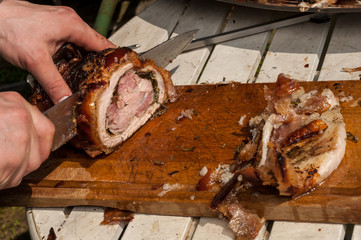 Affettatura della porchetta sul tagliere di legno