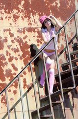 Sexy lady in pants and socks pose at stairs of metal structure