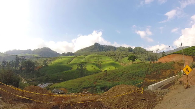 View from moving vehicle of tea plantations in the foothills on the roads of Sri Lanka.