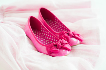Little girl's pink ballerina shoes on tutu skirt