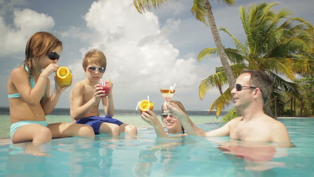 family having cocktails in pool