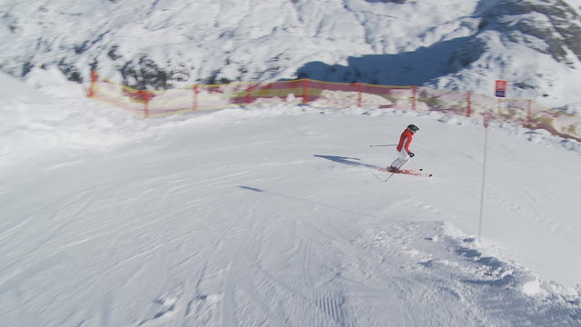 following skier on red ski slope