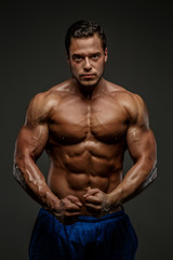 Fototapeta na wymiar Awesome muscular guy posing in studio.