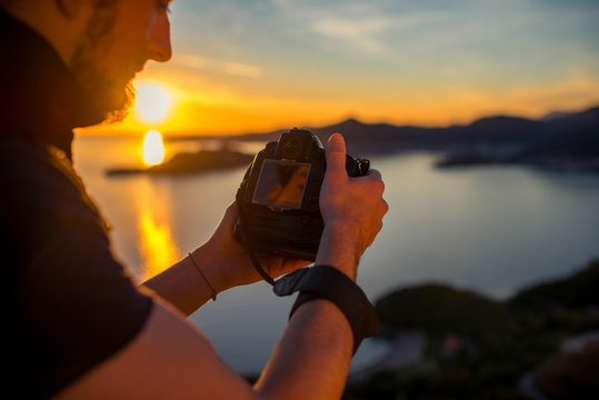 Man photographing sunset on the top of mountain