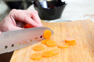 Chefs hands chopping carrot