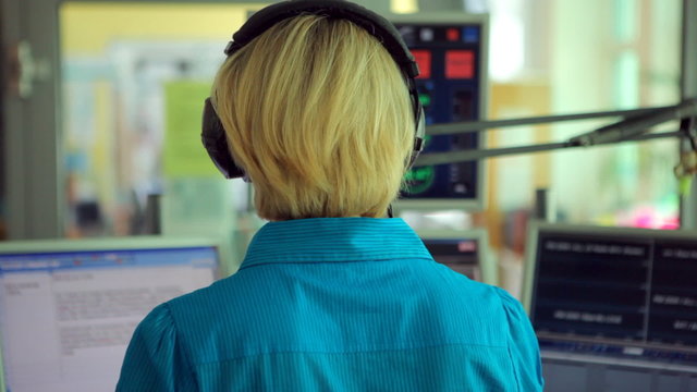 female radio moderator in studio from back
