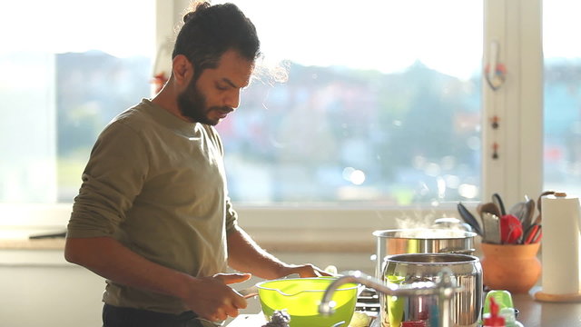 Young Indian man preparing lunch in the kitchen