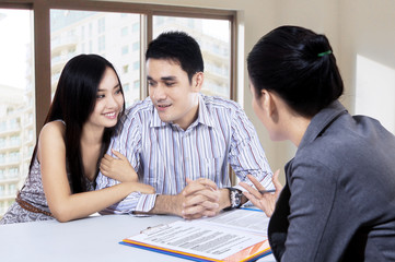 Young couple discussing with a financial agent