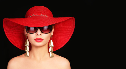 Woman in red hat and sunglasses over black - obrazy, fototapety, plakaty