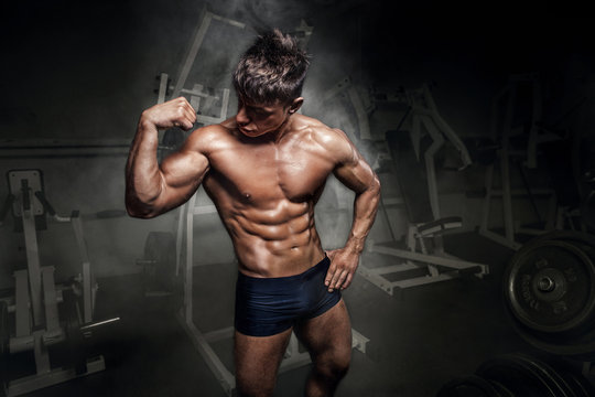 Bodybuilder man showing his biceps in gym