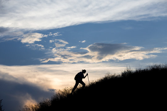 Silhouette of person heavy walking toward the summit