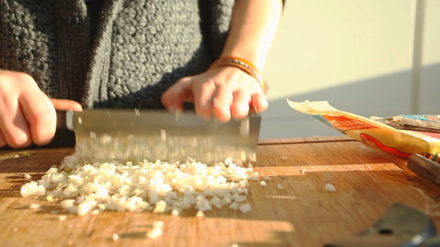 Female hands cutting vegetables on wooden board
