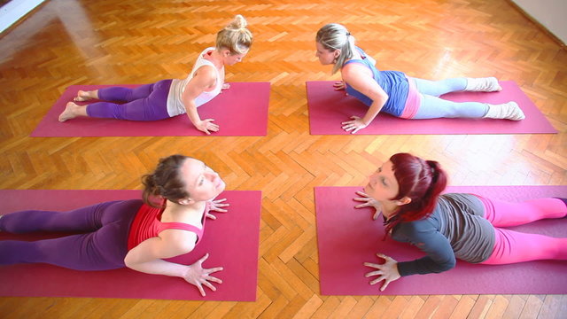 Women doing yoga class in hall