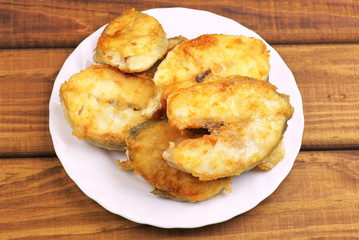 Cooked, fried pieces of fish on a white plate