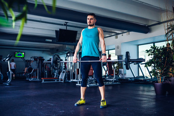 Fototapeta premium Crossfit instructor at the gym doing Deadlift exercises