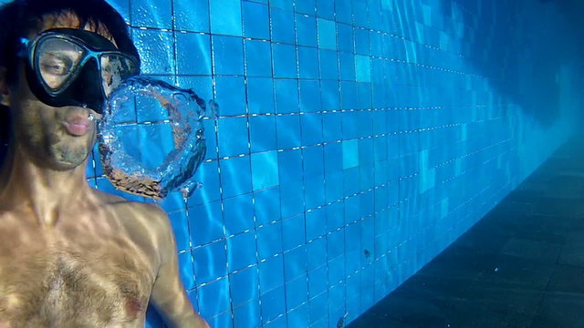 Man making bubble rings underwater in pool