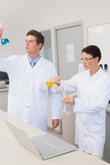 Scientists working attentively together with beakers