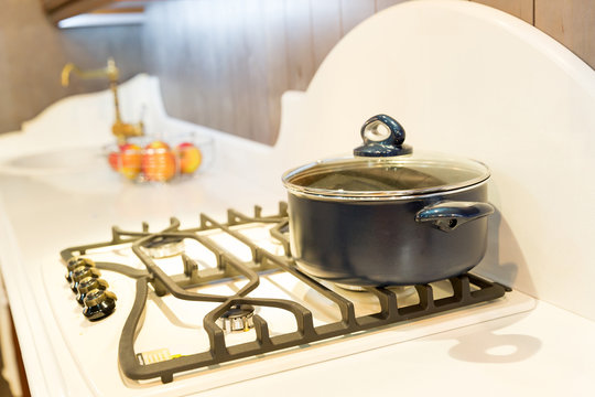Stove with saucepan on the white modern kitchen