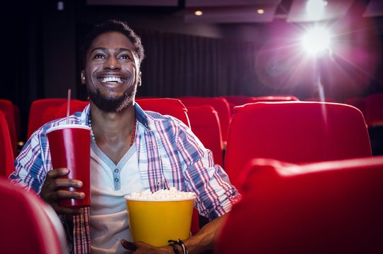 Happy young man watching a film