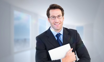 smiling businessman holding his laptop