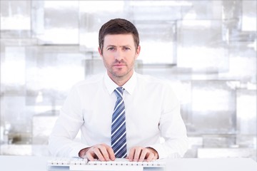 Composite image of businessman working at his desk