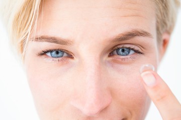 Pretty blonde applying contact lens