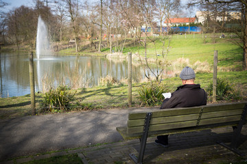 älterer mann auf einer parkbank
