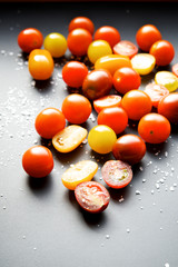 Multicolored cherry tomatoes on a black background