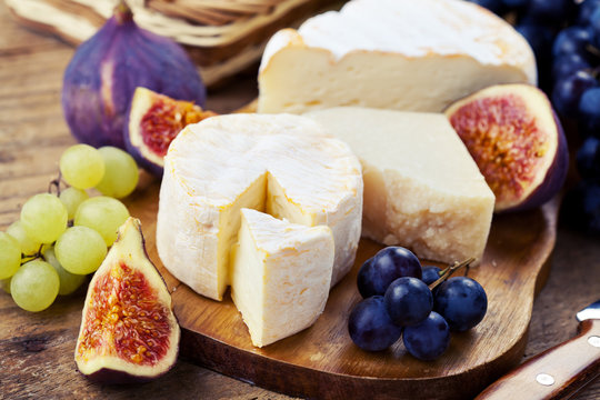 Cheese plate. Variety of cheese sorts with grapes and figs