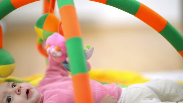 Innocent baby smiling and playing with toys