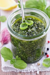 Basil pesto on a rustic wooden table.Selective focus.