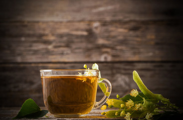 cup of tea with linden on wooden background