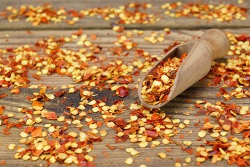 Milled Chili  Peppers Flakes And Corns On Wooden Board