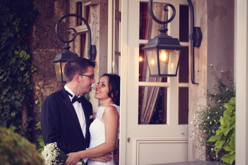 Fototapeta na wymiar Bride and groom near door with windows