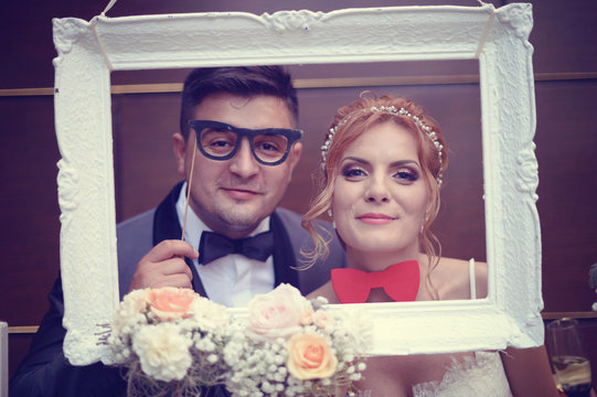 Funny bride and groom in a white frame