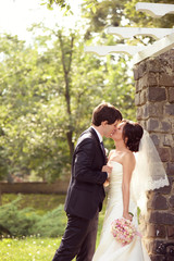 Bride and groom kissing in the park