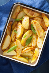 baked potato wedges in enamel baking dish
